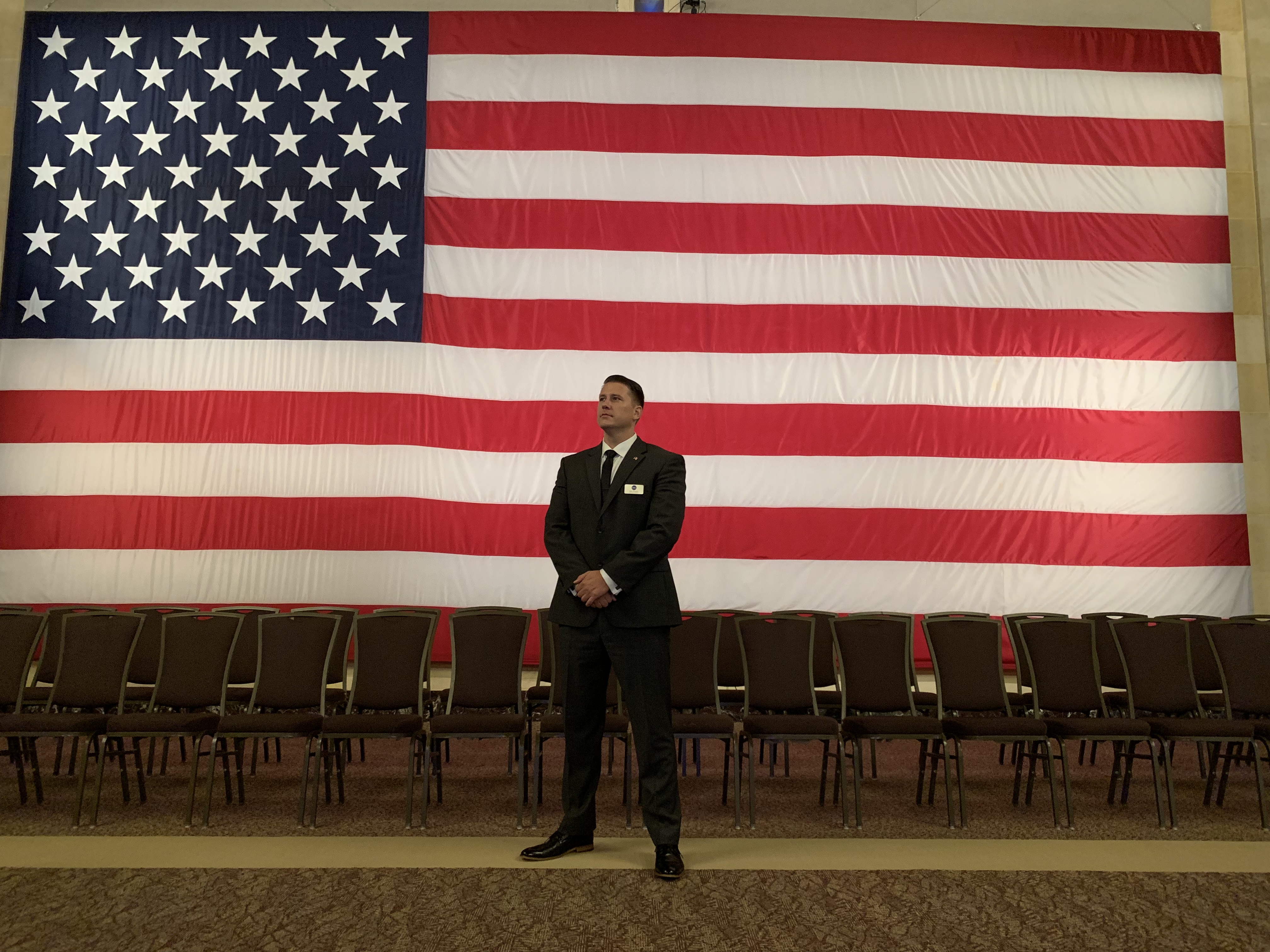 Founder standing before the American flag